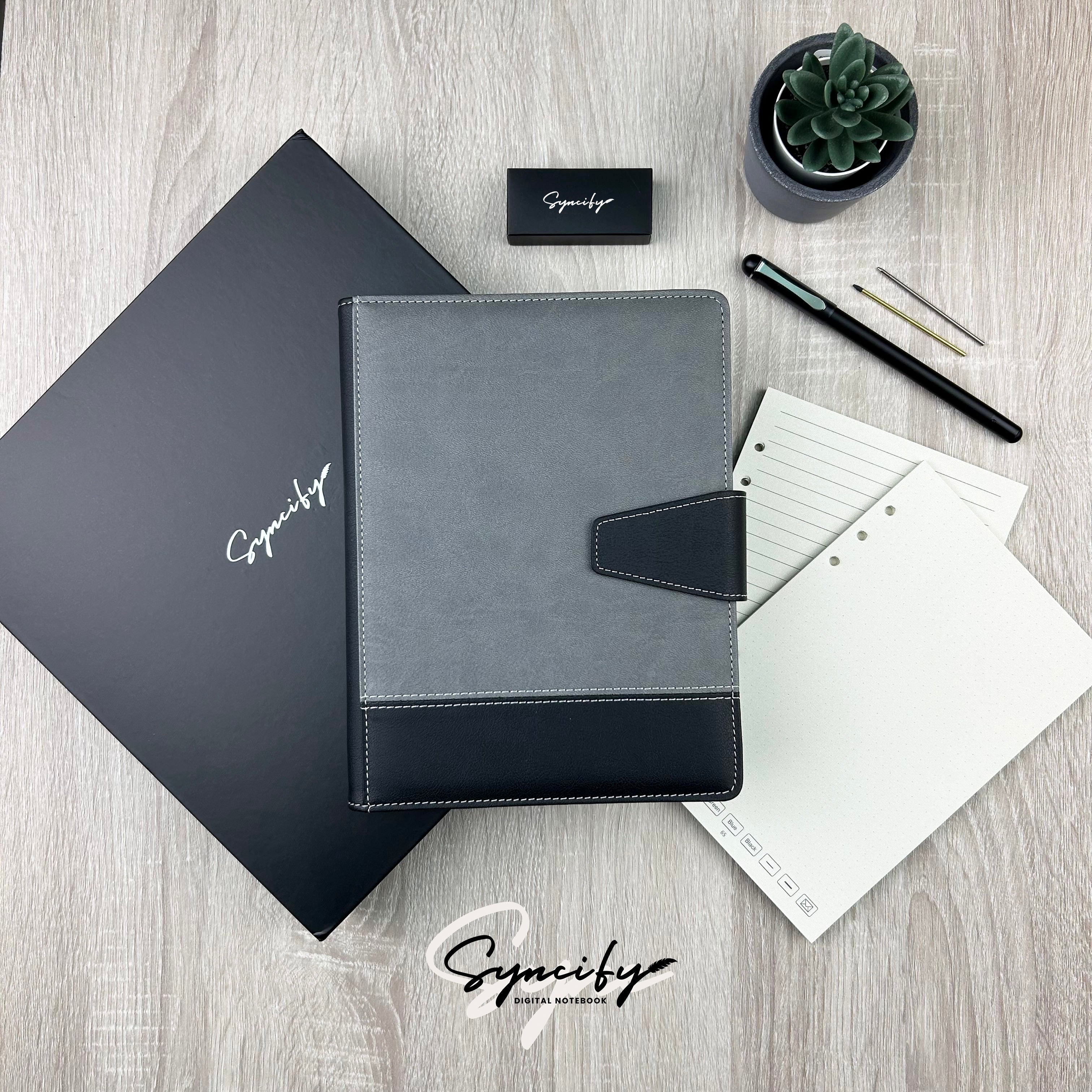 Syncifybook Sketchbook PRO V2 with gray and black cover, accessories, and a black Syncify box on wooden surface